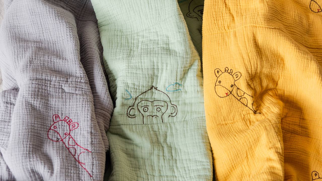 Load video: Hand Embroidered Baby blankets. Made in USA. Organic cotton baby blankets. Baby shower gifts. Social Impact, sustainable, ethical. Baby nursery ideas.